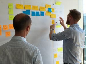 Two guys putting postits on the wall